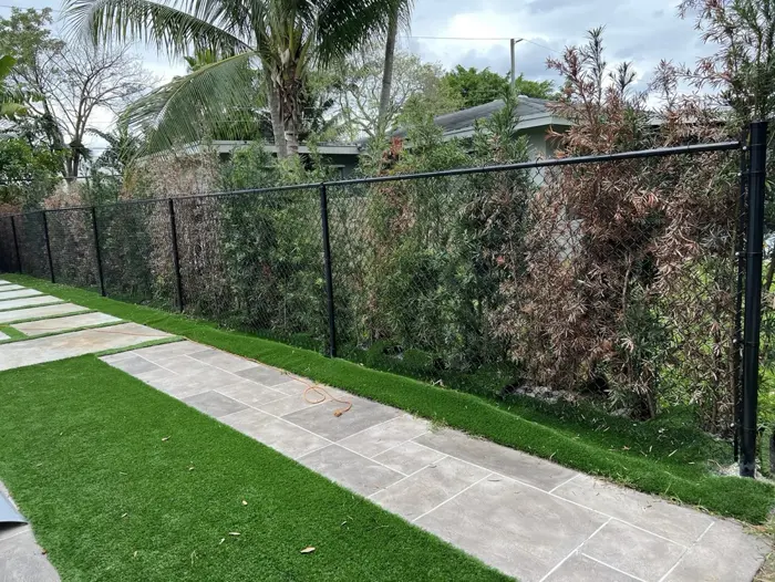 Black chain-link fence along a garden path