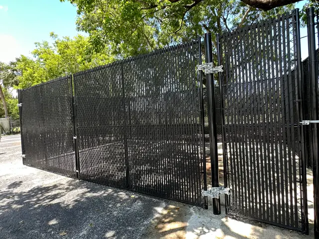 Black chain-link with privacy slats fence installed by Florida Fence Solution in Broward County